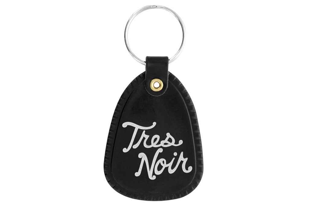Black saddle key chain with Tres Noir script logo on back